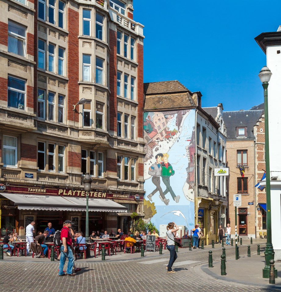 Brussels street scene with a comic book mural and restaurant.