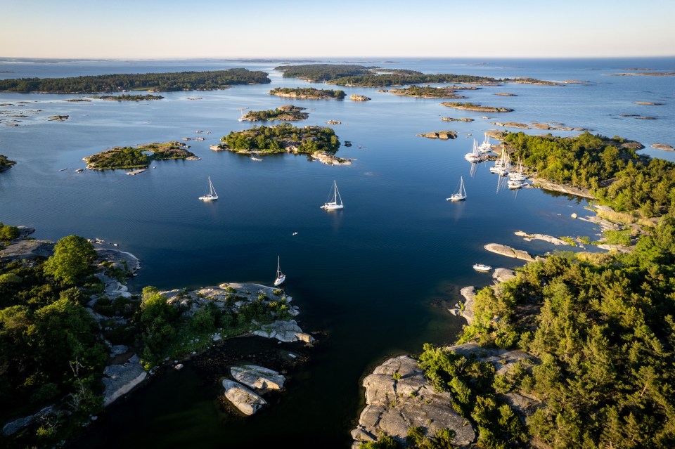Aerial view of sailboats anchored near islands.