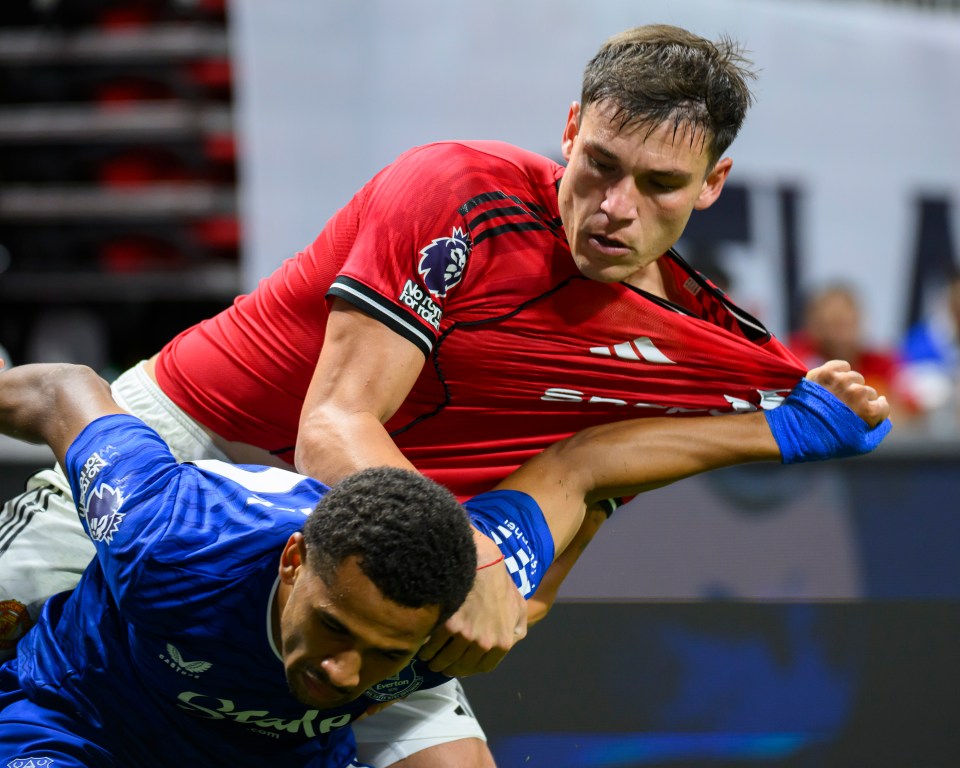 Manchester United's Manuel Ugarte wrestles with Everton's Iliman Ndiaye during a soccer match.