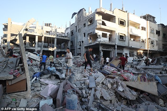 Residents in Gaza inspect the damage of an Israeli strike. A political analyst with Channel 12 quoted an unnamed official saying: 'Hamas won’t release more hostages without total surrender, and we won’t surrender