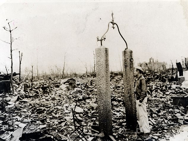 A Japanese man peers between two pillars that once marked the entrance to an up-market Japanese home in Hiroshima