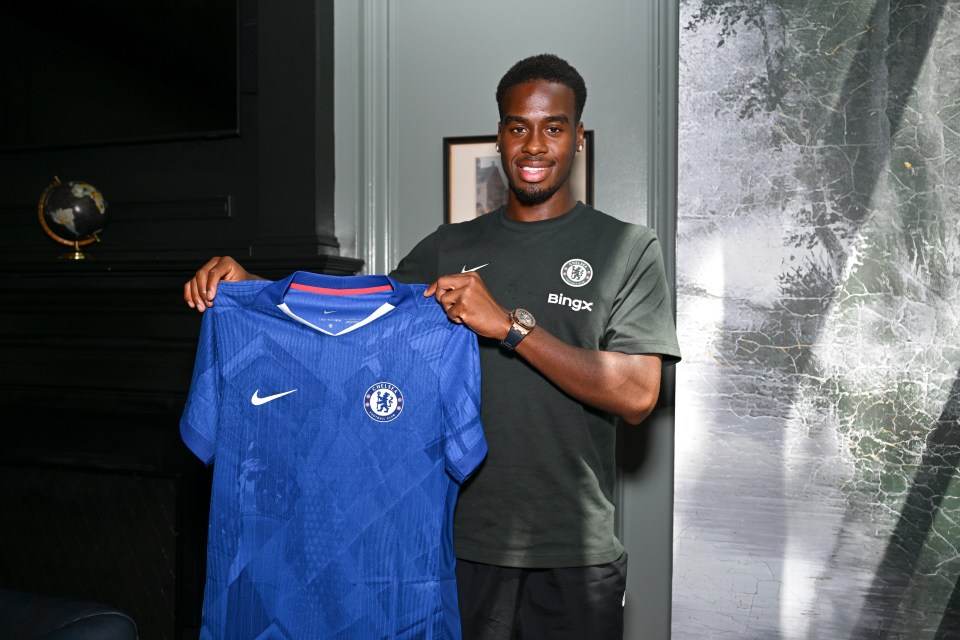 Jamie Gittens holding a Chelsea jersey.
