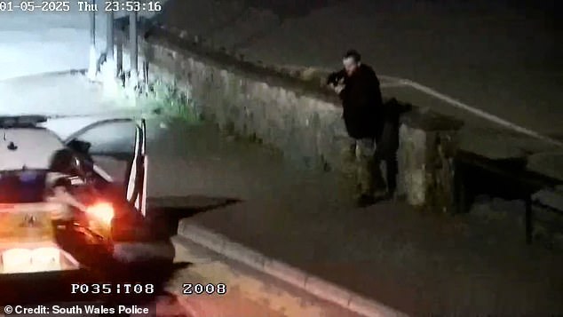 He later pulled the gun out and pointed it at a police officer who jolted back behind the car