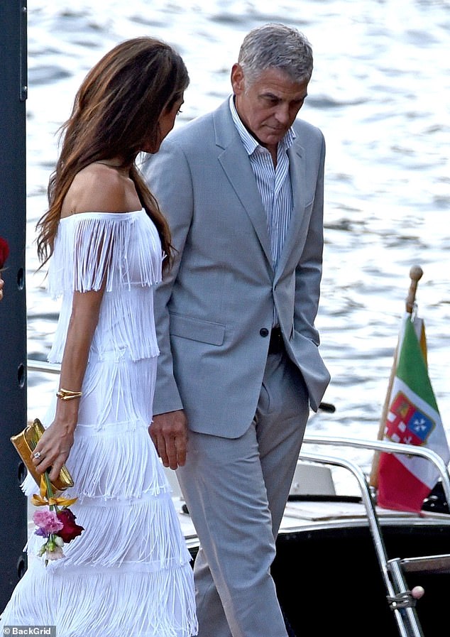 The actor nailed his suave look in a grey suit with a sharp striped shirt underneath, as he stepped onto a boat with his wife of nine years