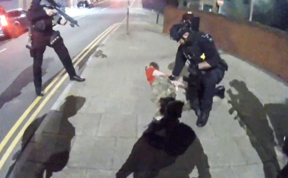Police officers arresting a man on the ground.