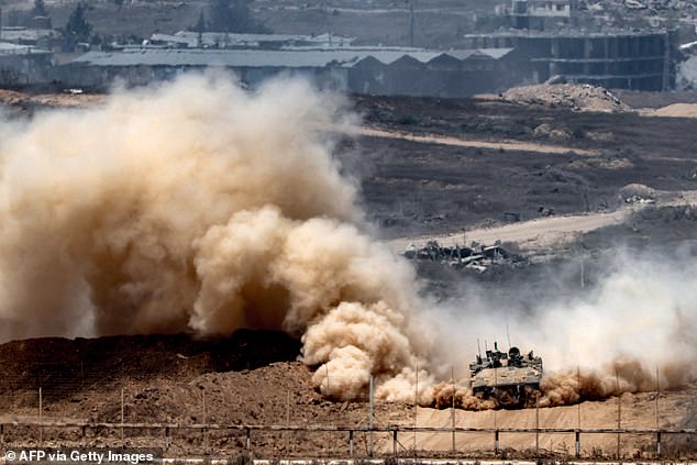 An Israeli army infantry-fighting vehicle (IFV) leaves a cloud of dust as it moves at a position along Israel's southern border with the Gaza Strip on August 5, 2025