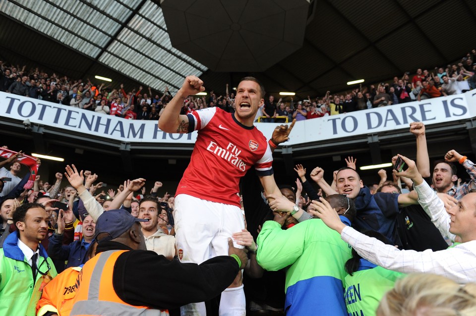 Lukas Podolski celebrates with Arsenal fans after a match.