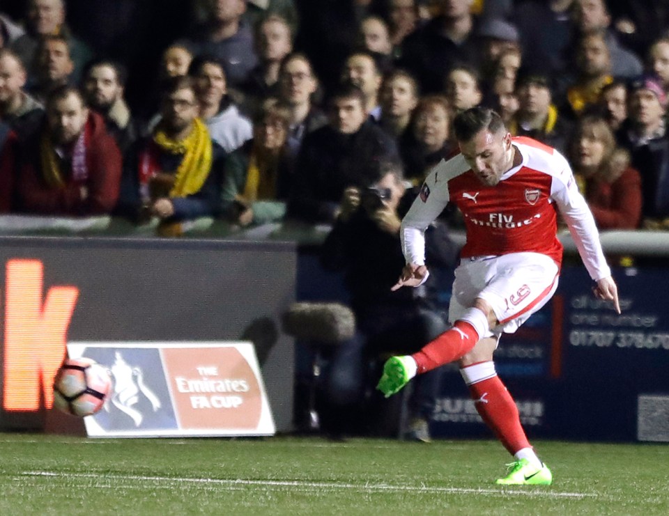 Lucas Perez of Arsenal kicking a soccer ball during a match.
