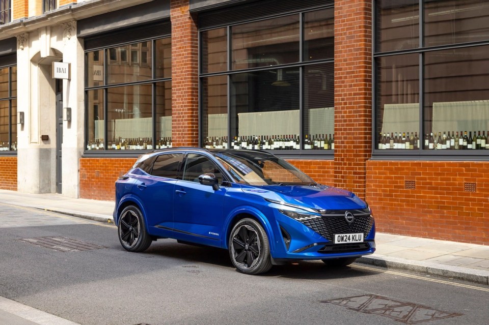 Blue Nissan Qashqai parked on city street.