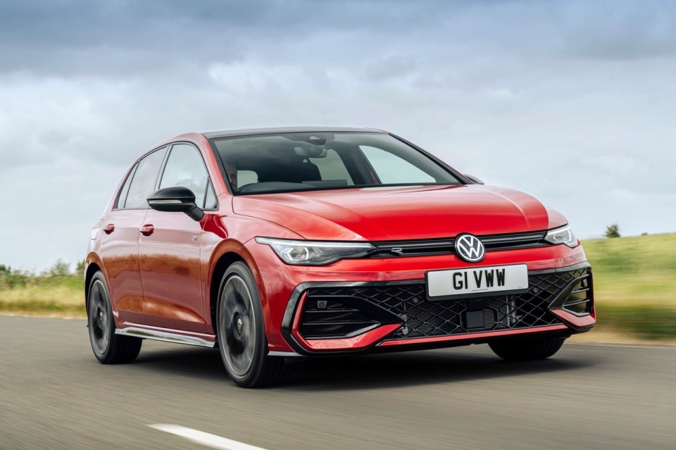 Red Volkswagen Golf driving on a road.