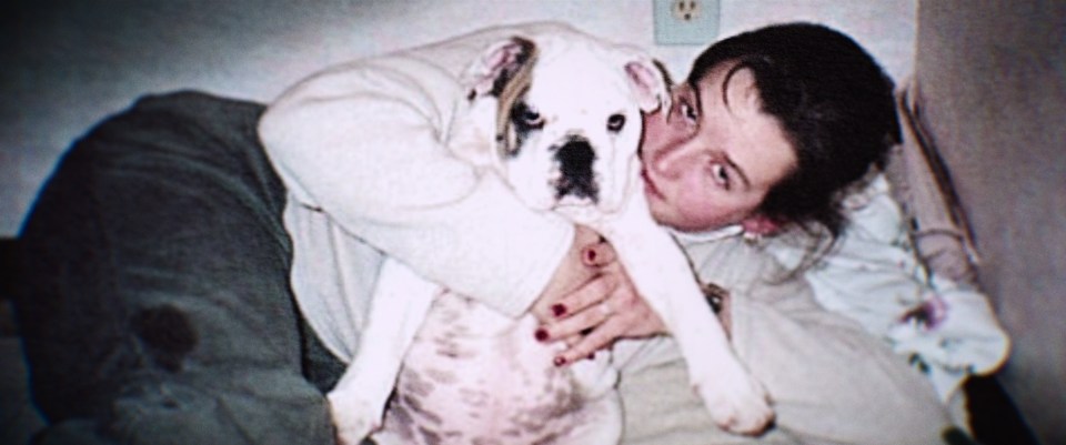 Photo of Amy Bradley as a young woman hugging a white bulldog.