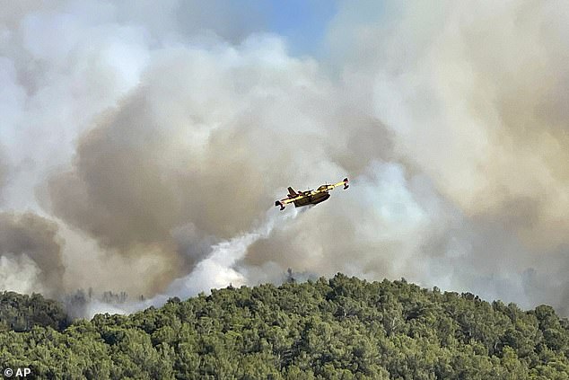 A water bomber plane dropping water on the wildfire in the Corbieres massif, southern France