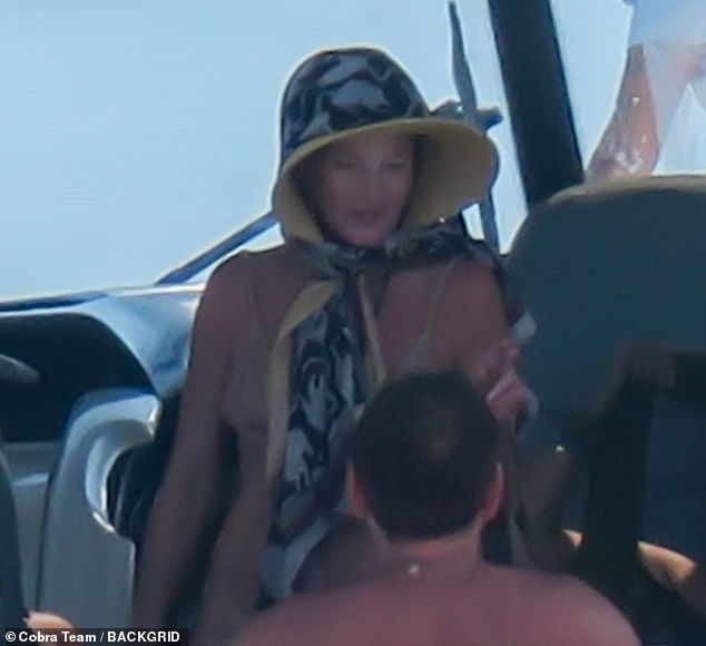 While on board Kate protected herself from the scorching sun under a kooky star hat and scarf
