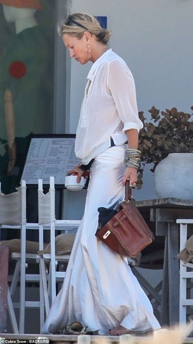 The catwalk queen slipped on a cream maxi skirt over her bikini bottoms
