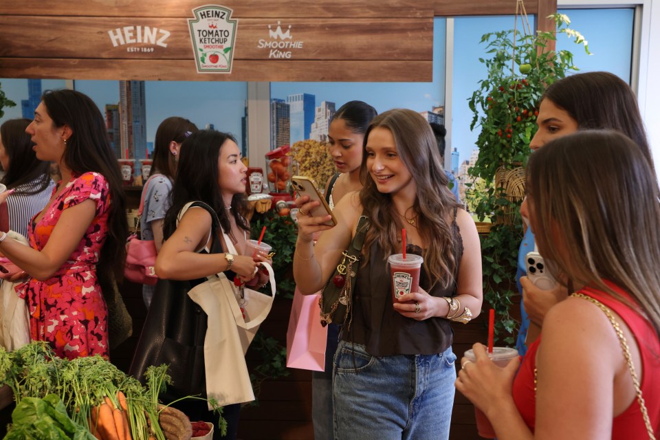 Women at a Heinz and Smoothie King event holding tomato ketchup smoothies.