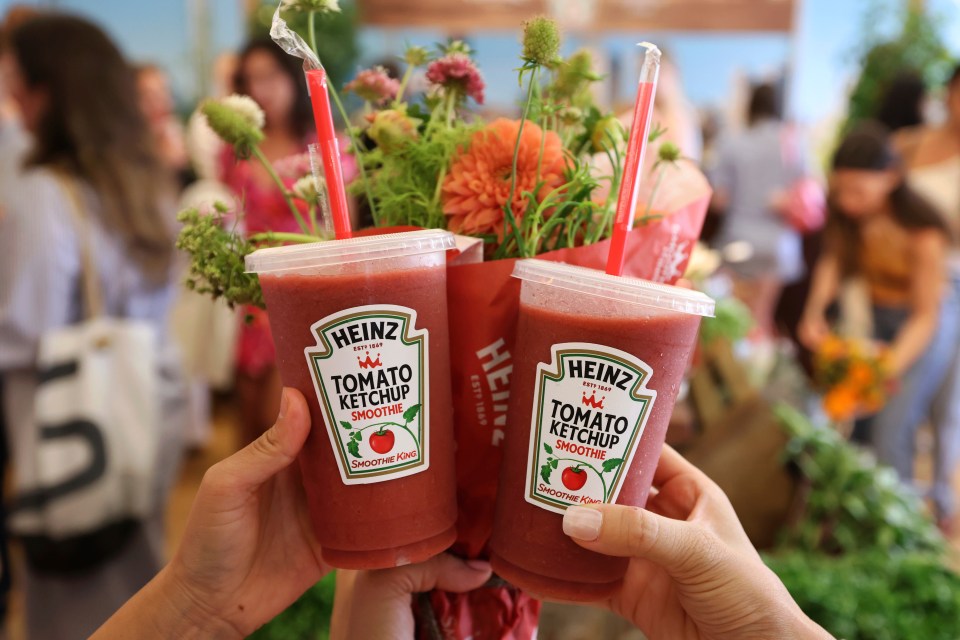 Two hands holding Heinz Tomato Ketchup smoothies.