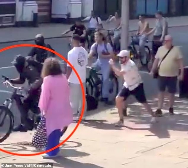 A cyclist thief stealing a man's phone on the street during broad daylight in central London