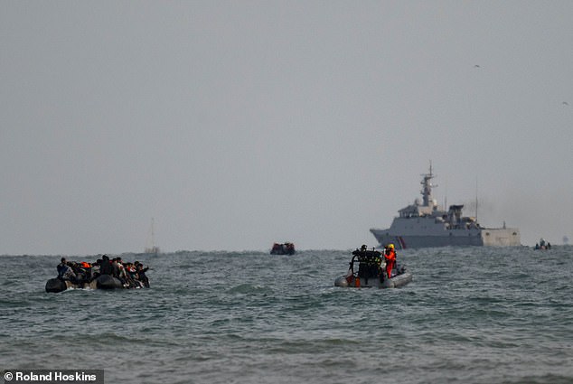 A boat packed with migrants is seen sailing away from Gravelines beach today