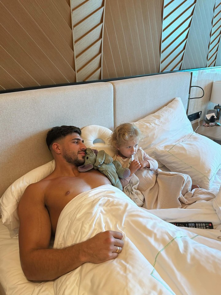 Tommy Fury and his daughter in bed.