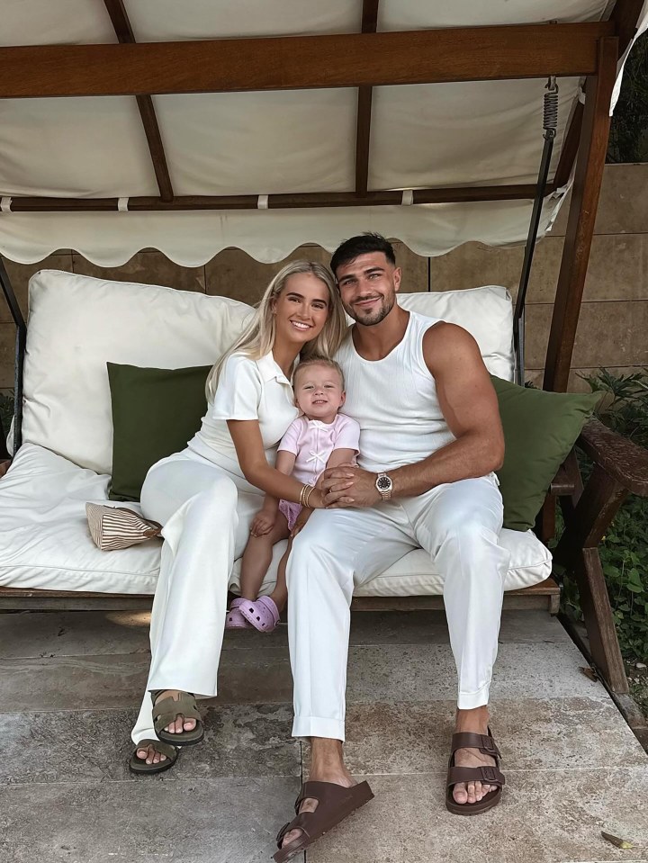 Tommy Fury, Molly Mae, and their baby sitting together.