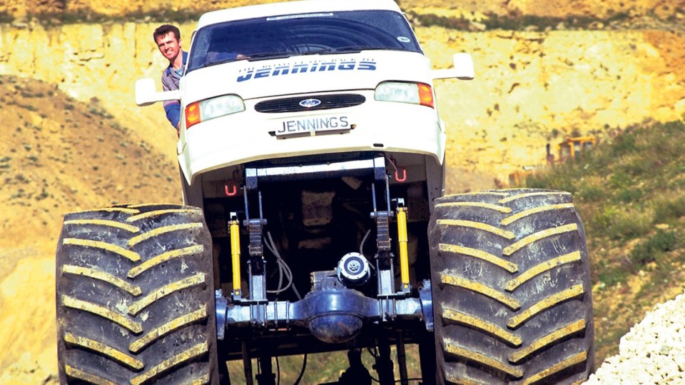 Monster truck with a driver leaning out of the window.