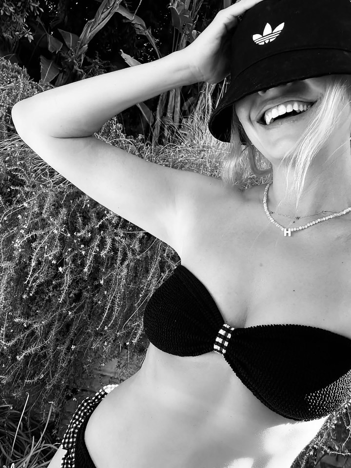 Black and white photo of a woman in a bikini and bucket hat.