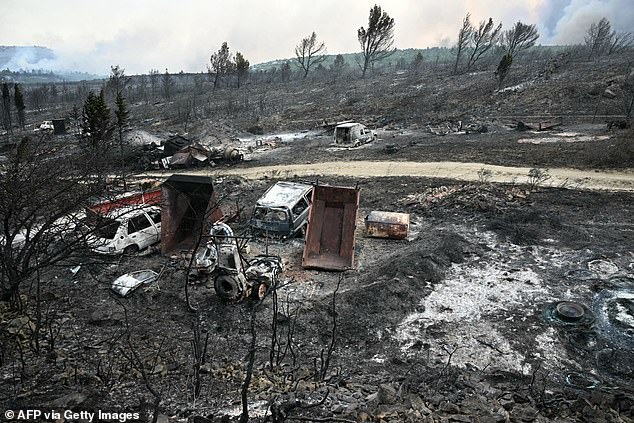 This photograph shows burnt vehicles in an area devastated by a wildfire near Fontjoncouse, southwestern France