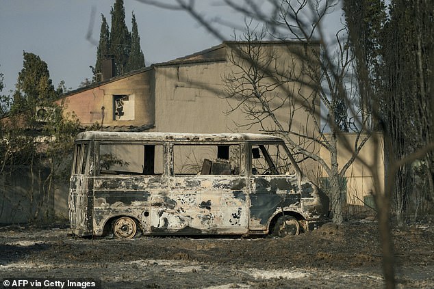 A burnt van is seen in front of a home burned due to a wildfire brokes out in Saint-Laurent-de-la-Cabrerisse