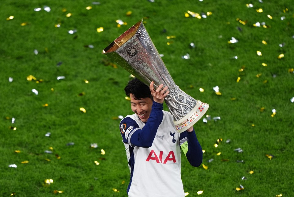 Son Heung-min lifts a trophy after a soccer game.