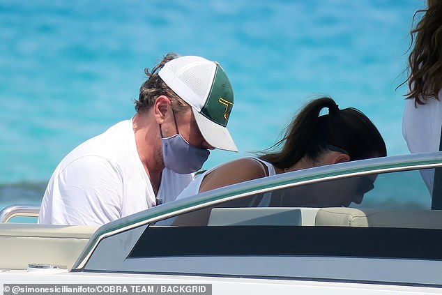 Leo covered his face with a medical face mask as he departed the tender and headed onto land