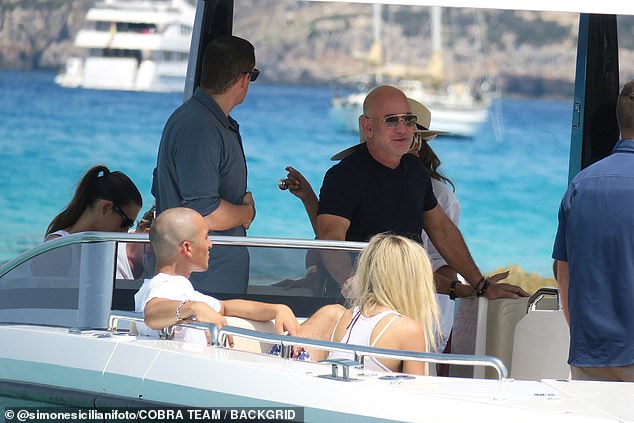 They were seen relaxing on a tender boat as they were taken to shore to enjoy a day exploring the smallest of the Balearic islands