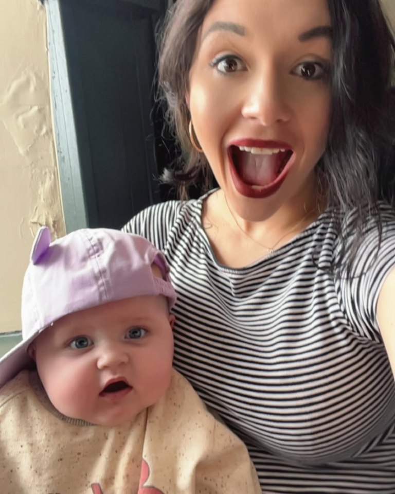 Woman holding baby wearing a hat.