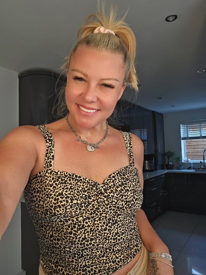 Woman smiling in leopard print top after receiving a mummy makeover.