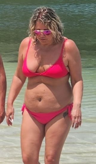Woman in pink bikini at the beach.