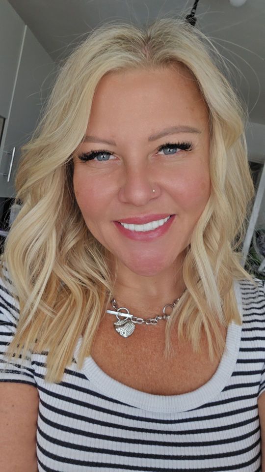 Woman smiling after a mummy makeover.