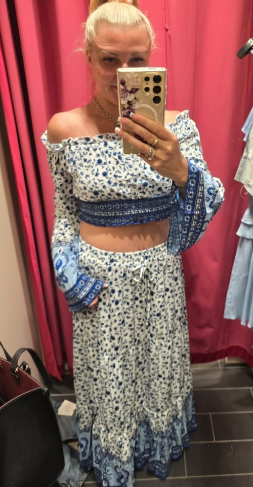 Woman in blue and white floral crop top and maxi skirt.