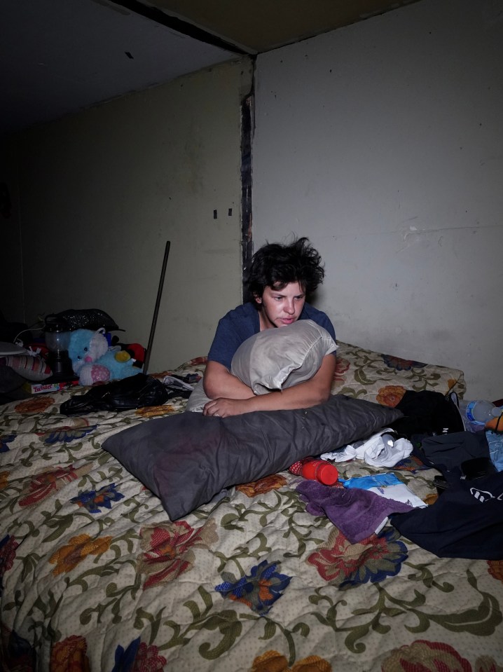 Homeless man sitting on a bed in a Las Vegas tunnel.