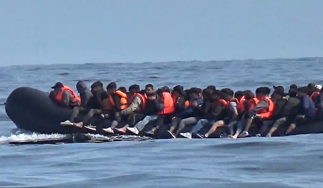 An overloaded dinghy of migrants in the Channel yesterday