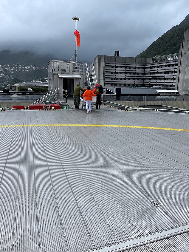 The journalist is wheeled into hospital from the helipad after suffering a broken femur