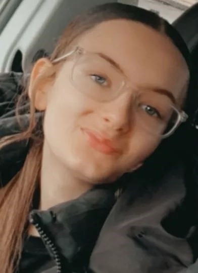 Photo of a teenage girl wearing clear glasses.