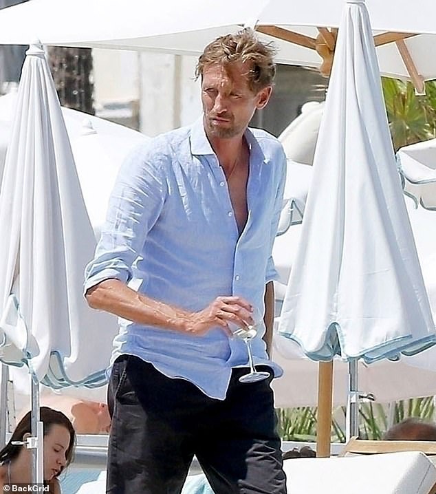 Peter later slipped into a blue linen shirt as he sipped on a glass of wine