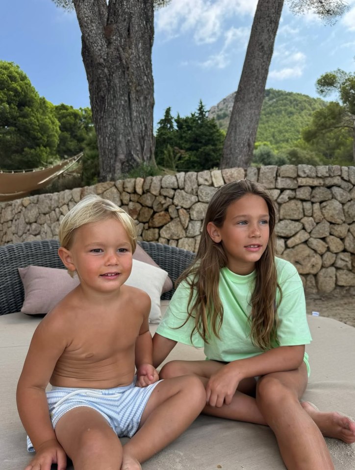 Two young children sitting outdoors.