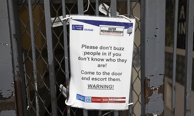A sign on a doorway asking residents not to allow entry to strangers