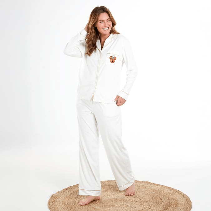 Woman in white pajamas with embroidered reindeer.
