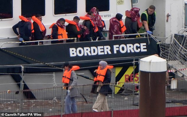Migrants disembark from the UK Border Force catamaran, Ranger, at the port of Dover today after being picked up in the Channel
