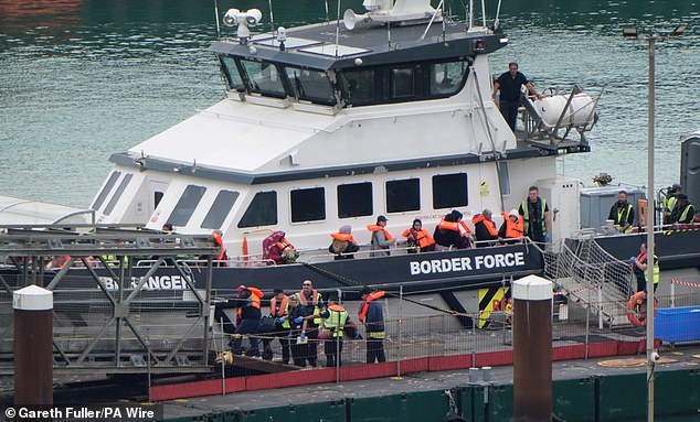 Several dozen migrants, many wearing orange lifejackets, left the Border Force vessel at the Western Jet Foil, in Dover port, today after being picked up mid-Channel by immigration officials