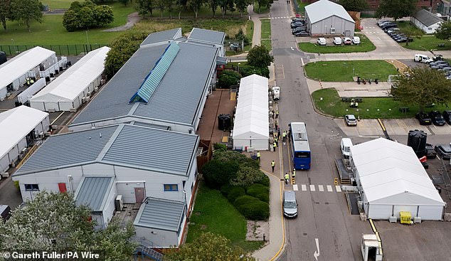 Migrants leave a coach at the Manston Immigration Processing Centre