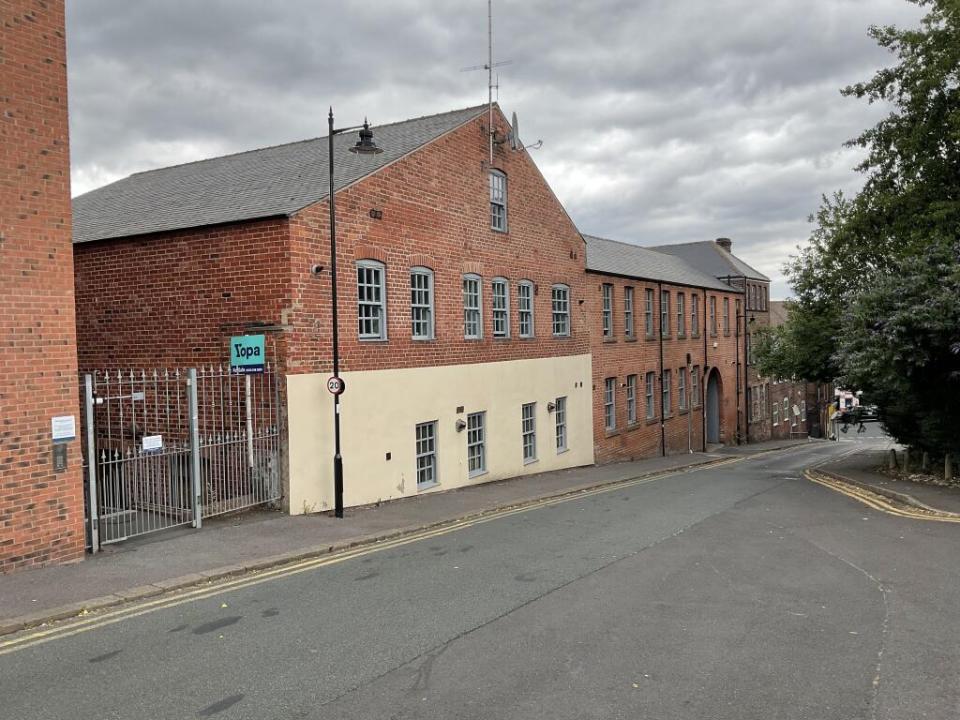 Exterior view of a narrow brick building for sale.