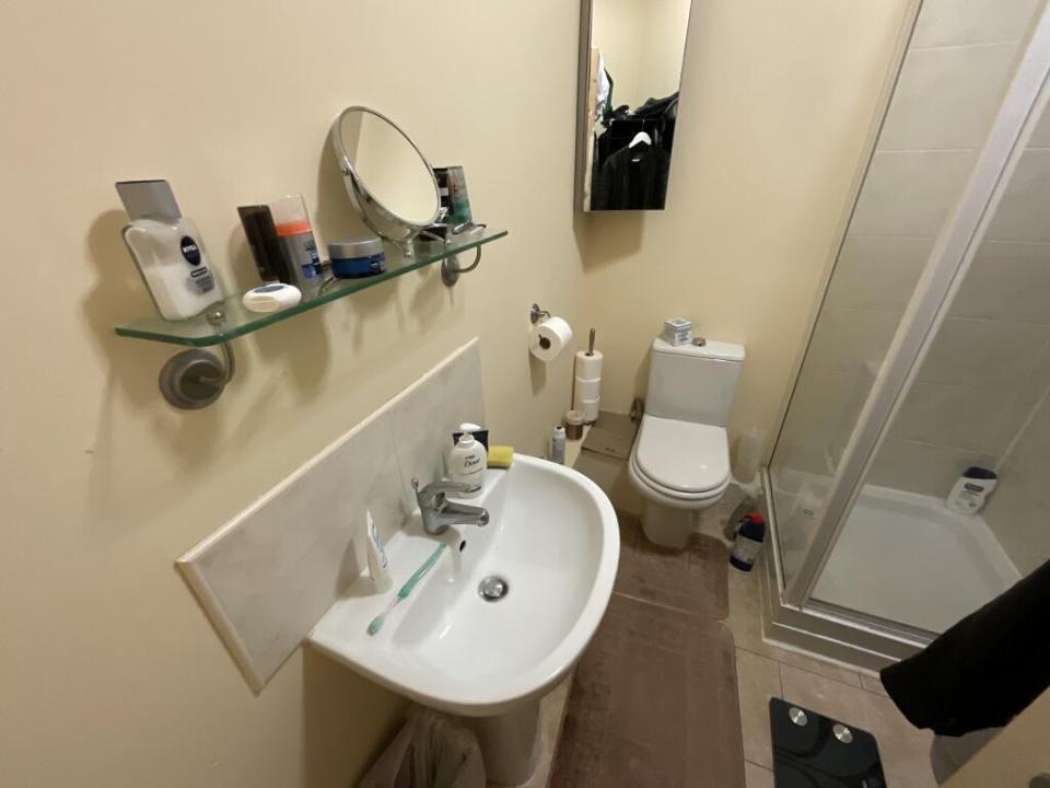 Small bathroom with shower, toilet, and sink.