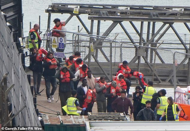 A group of people thought to be migrants are brought into the Border Force compound in Dover, Kent, on Thursday